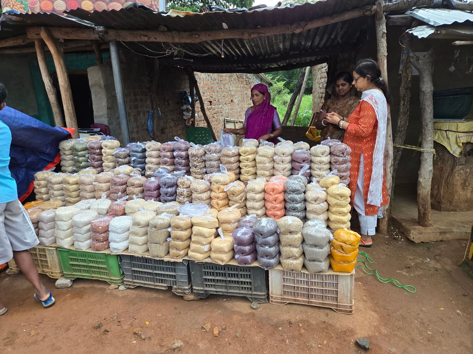 Pyramid of graded produce packs under a bamboo shelter in Rayagada