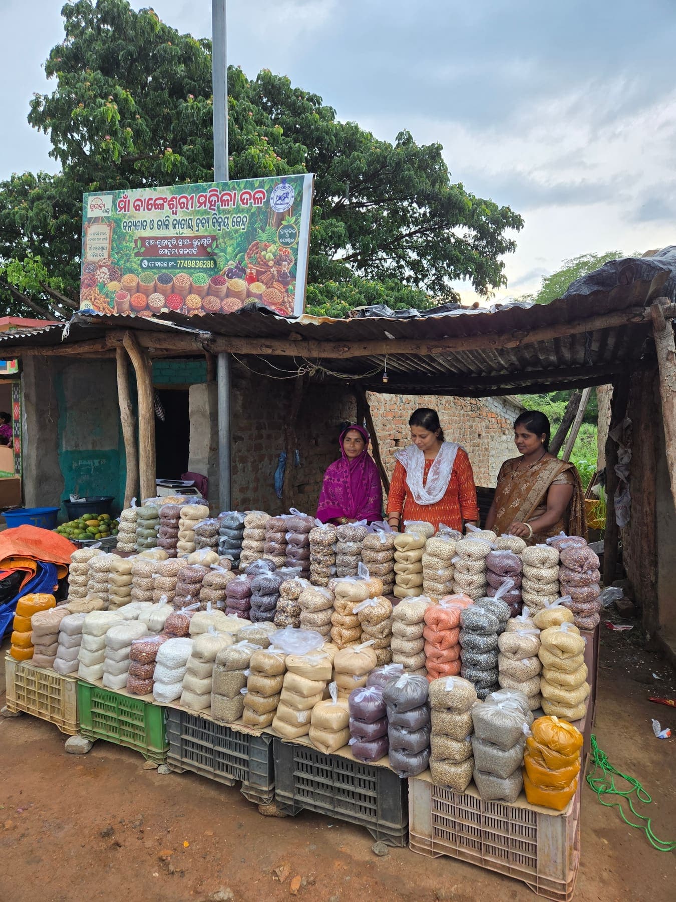 Village collective stall with banner and stacked produce packs