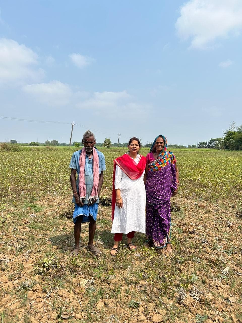 Standing with two producers at the edge of a field in Ganjam
